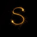 Alphabet sparklers on black background single letter