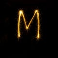 Alphabet sparklers on black background single letter