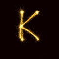 Alphabet sparklers on black background single letter