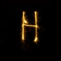 Alphabet sparklers on black background single letter