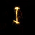 Alphabet sparklers on black background single letter