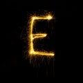 Alphabet sparklers on black background single letter