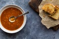 Alphabet soup with the word soup in the spoon served with grilled cheese.