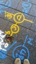 Alphanumeric and symbol spray paint markings on a pedestrian footpath