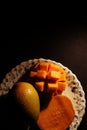 Alphonso mango ripe slice on white plate dark background
