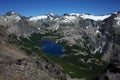 Alpine blue lake surrounded by gray lifeless rocky mountains under blue sky, Jakob lagoon in Nahuel Huapi National Park