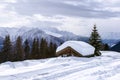 Alpine chalet sunk in deep snow in winter with thick snow on roof in the Swiss Alps Royalty Free Stock Photo