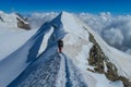 Alpine climber, alpinist on a knife edge of snow mountain in the Alps