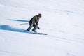 Alpine downhill skier speeding down a steep slope in bright winter sunlight