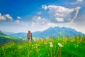 Alpine hiking lonely girl in a flowery meadow