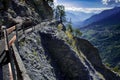 Alpine hiking trail, narrow path along the mountainside, valley and mountain background, Switzerland