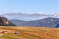 Alpine huts on the Seiser Alm plateau and snow capped peaks of the Dolomites Royalty Free Stock Photo