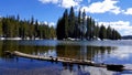 Alpine lake with timber in the front with amazing sky and clouds.