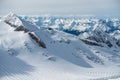 Alpine landscape with peaks covered by snow and clouds, beautiful colors at the top of a glacier. Royalty Free Stock Photo