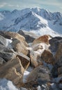 Alpine landscape with rocks at the front, peaks covered by snow and clouds, beautiful colors at the top of a glacier Royalty Free Stock Photo