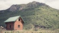 An Alpine meadow with wild flowers and an old wooden farmhouse. hut cabin in mountain alps at rural fall landscape Royalty Free Stock Photo