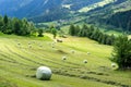 Alpine mountain landscape with farm fields and hay bales in the Swiss Alps above Andeer village Royalty Free Stock Photo