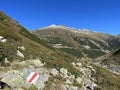 Alpine mountaineering signposts and markings in the mountainous area of the Albula Alps and above the mountain road pass Fluela