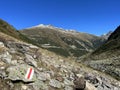 Alpine mountaineering signposts and markings in the mountainous area of the Albula Alps and above the mountain road pass Fluela