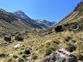 Alpine mountaineering signposts and markings in the mountainous area of the Albula Alps and above the mountain road pass Fluela