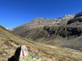 Alpine mountaineering signposts and markings in the mountainous area of the Albula Alps and above the mountain road pass Fluela