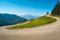 Swiss alpine panorama with u-turn mountain road and green pastures