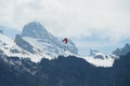 Alpine peaks covered with snow landscape in early spring with a para-glider  with red glide flying above. Royalty Free Stock Photo