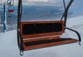 Alpine resortr ski lift with seats going over the sunset mountain skiing  slopes in extremally windy weather Royalty Free Stock Photo
