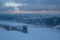 Alpine resortr ski lift with seats going over the sunset mountain skiing  slopes in extremally windy weather Royalty Free Stock Photo