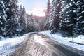 Alpine road through a snowy forest in winter