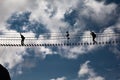 Alpine rope suspension bridge with a person against blue sky Royalty Free Stock Photo