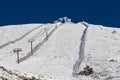 Alpine ski slope covered with snow. Chair lifts on the ski slope. Royalty Free Stock Photo