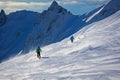 Alpine skiers embrace the stunning snowy backdrop of the mountain range