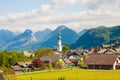 Alpine village St. Gilgen with a church, mountains on background