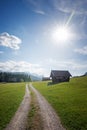 Alpine walkway near Gerold, spring landscape with huts and bright sun, blue sky with clouds Royalty Free Stock Photo