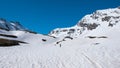 Alpinist hiking ski touring on snowy slope towards the mountain summit. Concept of conquering adversities and reaching the goal.