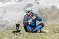 Alpinist makes a tea break before breathtaking mountain views