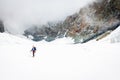 Alpinist moutaineer standing glacier looking rock cliffs