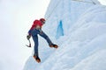 Alpinist woman with ice tools axe in orange helmet climbing a l Royalty Free Stock Photo