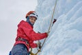 Alpinist woman with ice tools axe in orange helmet climbing a l Royalty Free Stock Photo