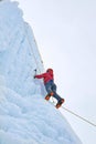 Alpinist woman with ice tools axe in orange helmet climbing a l Royalty Free Stock Photo