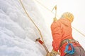 Alpinist woman with ice tools axe in orange helmet climbing a l Royalty Free Stock Photo