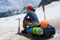 Alpinist woman sitting on her backpack