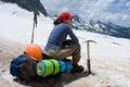 Alpinist woman sitting on her backpack
