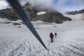 Alpinists team tight by rope surrounded by rocky mountains in the fog in Austrian Alps near the Grossglockner rock summit, Kals am Royalty Free Stock Photo