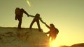 Team of climbers climbs a mountain holding out a helping hand to each other. Free woman traveler climb mountain Royalty Free Stock Photo