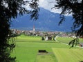 The Alps - Austrian village with typical church spire with mountains Royalty Free Stock Photo