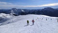 on alps hikers walk on snow to reach snowy peak of mountain top in Italy