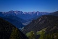 Alps mountain meadow tranquil summer view. Landscape with fog in mountains and rows of trees Royalty Free Stock Photo