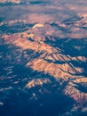 The Alps mountains at a sunset seen through the plane window pane.